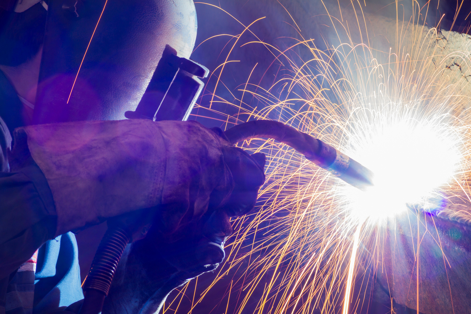 Worker welding steel by MIG-MAG weld (Argon welding).